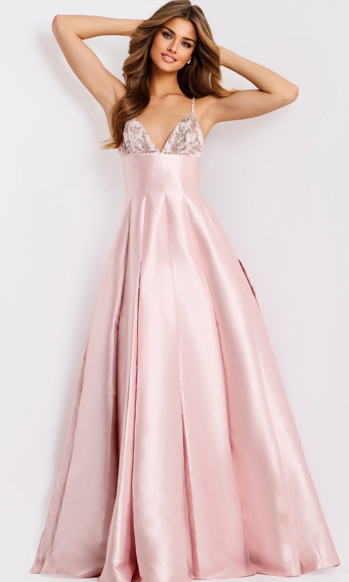 A woman poses in the Jovani 48732 long prom dress—a floor-length, light pink satin gown with a fitted bodice, spaghetti straps, and lace detailing at the top.